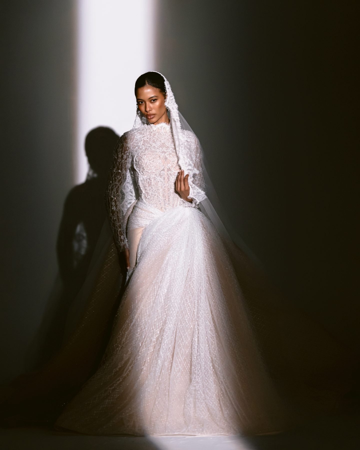 Bride in a hand-embroidered gown lit by a single beam of light